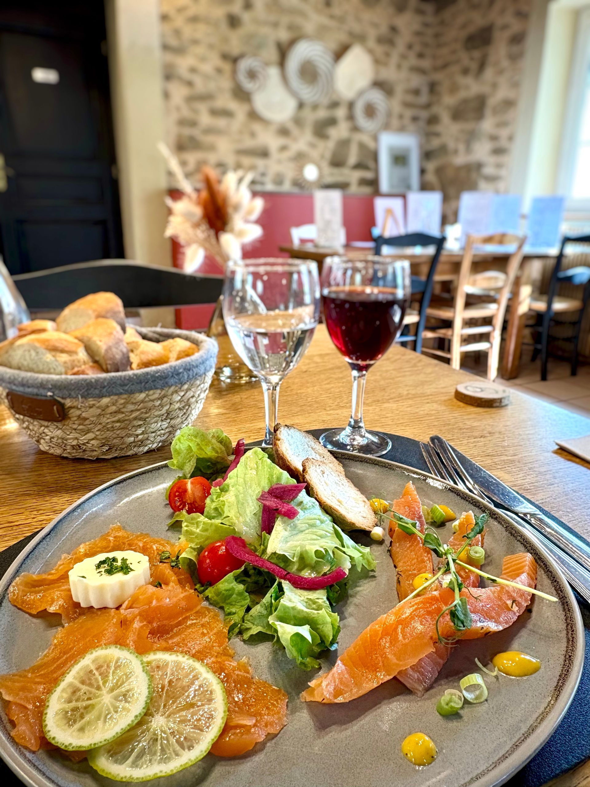 Tranche de clafoutis aux cerises avec crème fouettée et sauce, servie sur une assiette blanche.