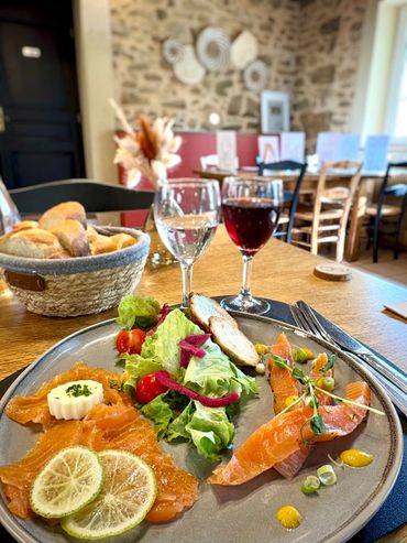 Tranche de clafoutis aux cerises avec crème fouettée et sauce, servie sur une assiette blanche.