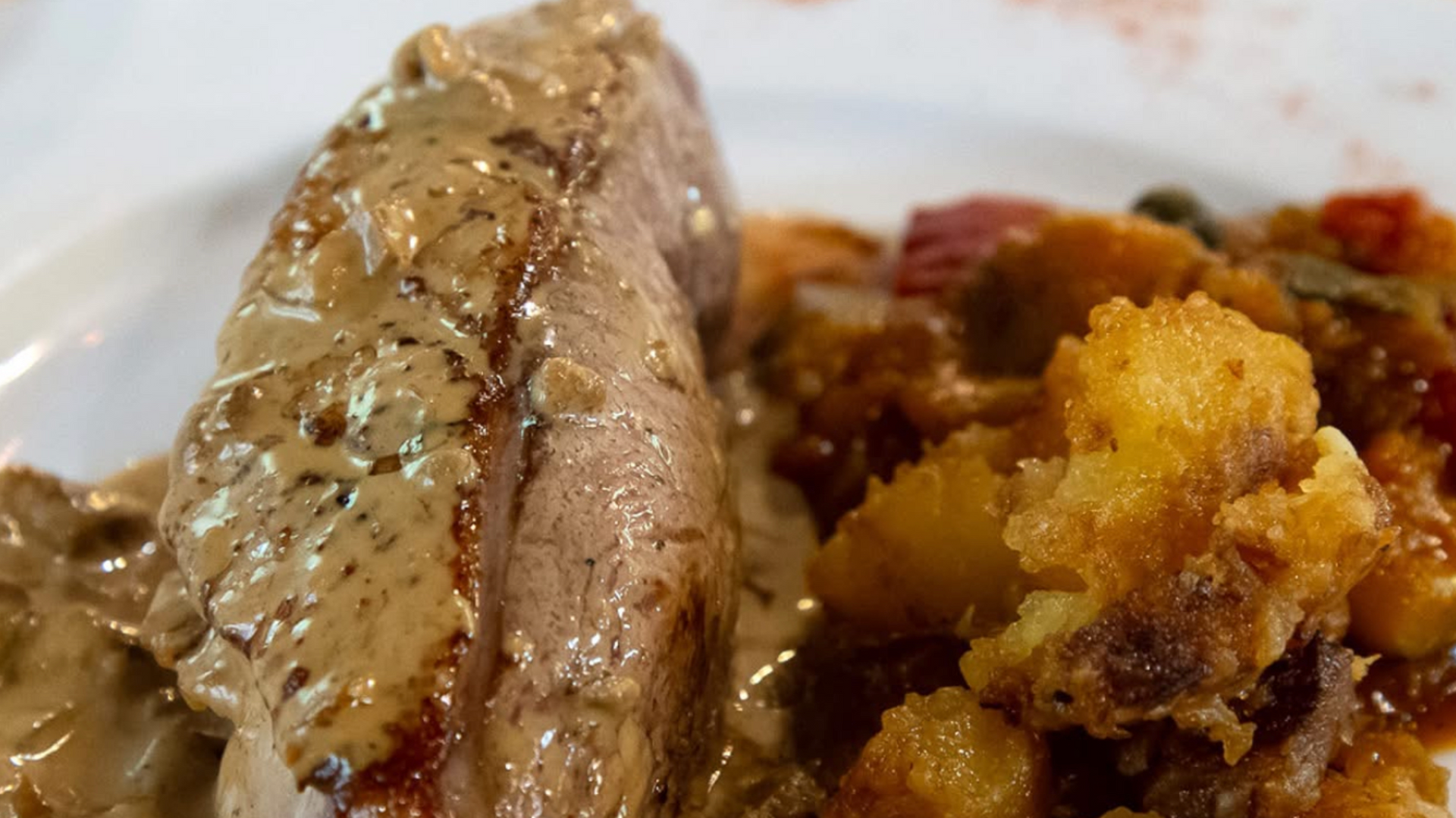 Plat de pâté garni de feuilles, servi avec des cornichons dans de petits plats blancs.