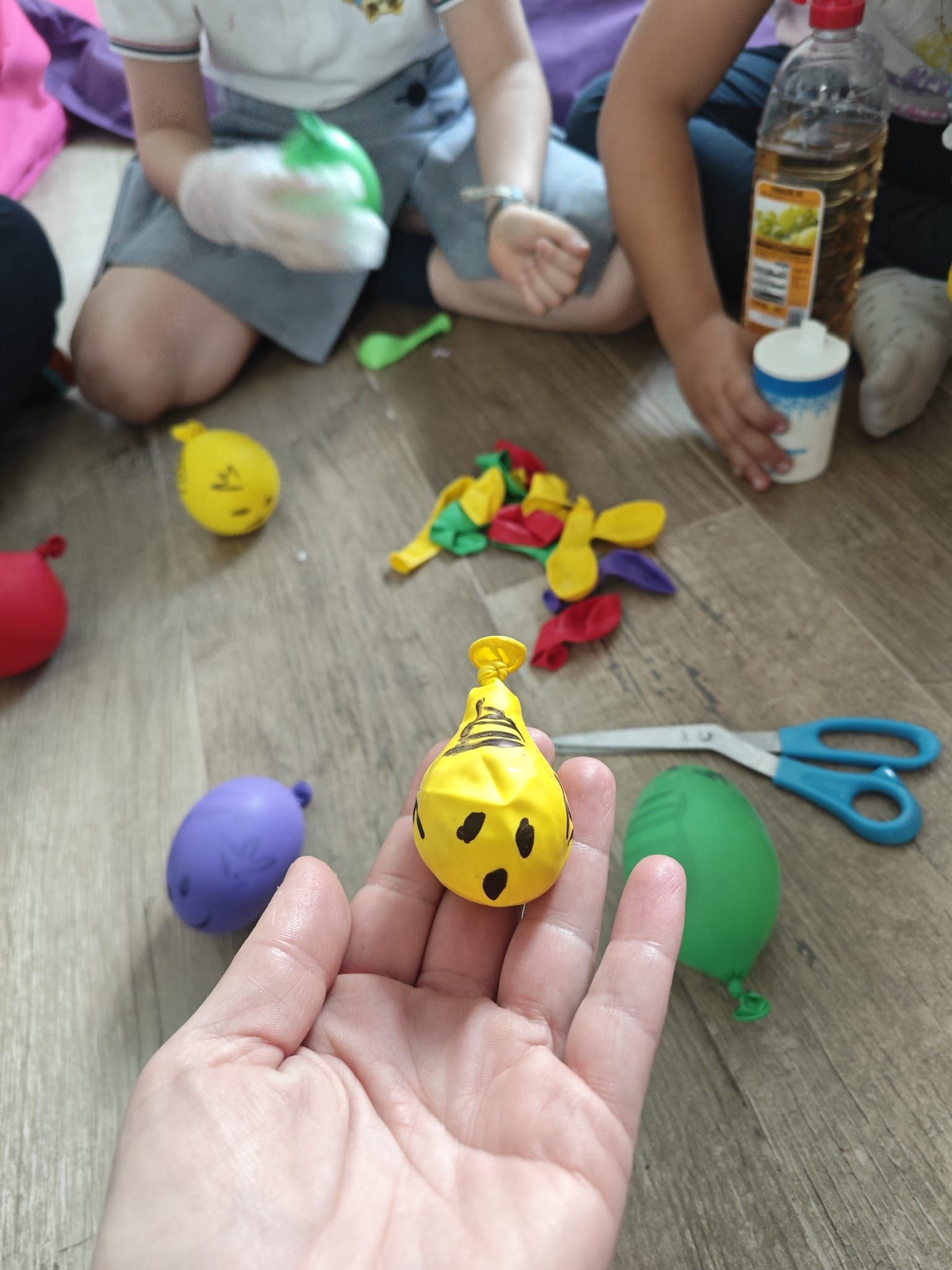 Una persona sostiene un globo amarillo con una cara.
