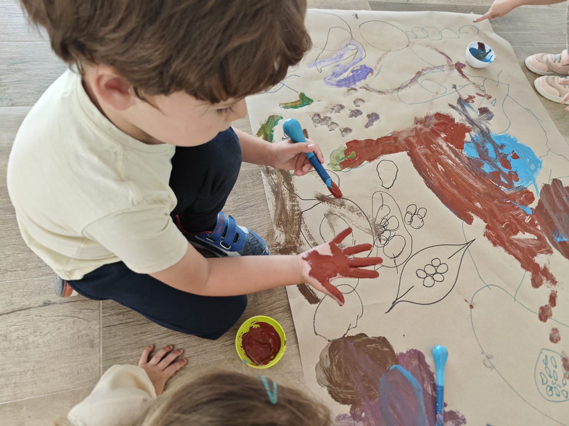 Un niño y una niña están pintando en un trozo de papel.