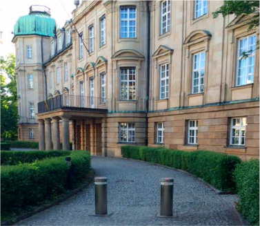 Ein Weg führt an einer Kirche und einem Gebäude mit kahlen Bäumen vorbei.