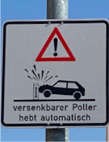 Warning sign: Red triangle over car hitting a rising bollard. Text: