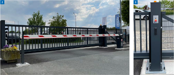 Ein Sicherheitstor mit einer rot-weiß gestreiften Barriere bewacht einen Eingang auf einer gepflasterten Fläche.