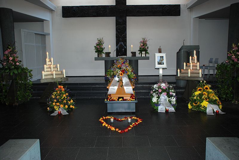 Eine Kirche mit Blumen und Kerzen und einem Kreuz im Hintergrund