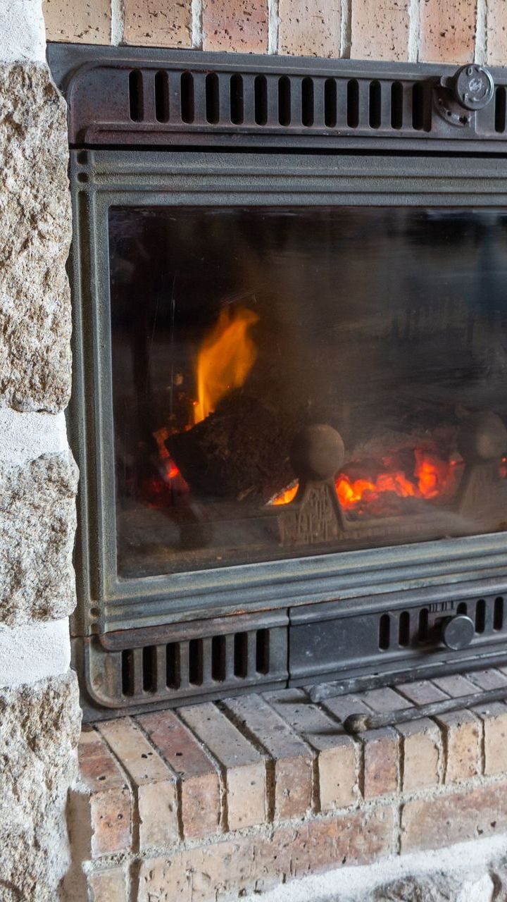 Insert avec feu dans une cheminée traditionnelle.
