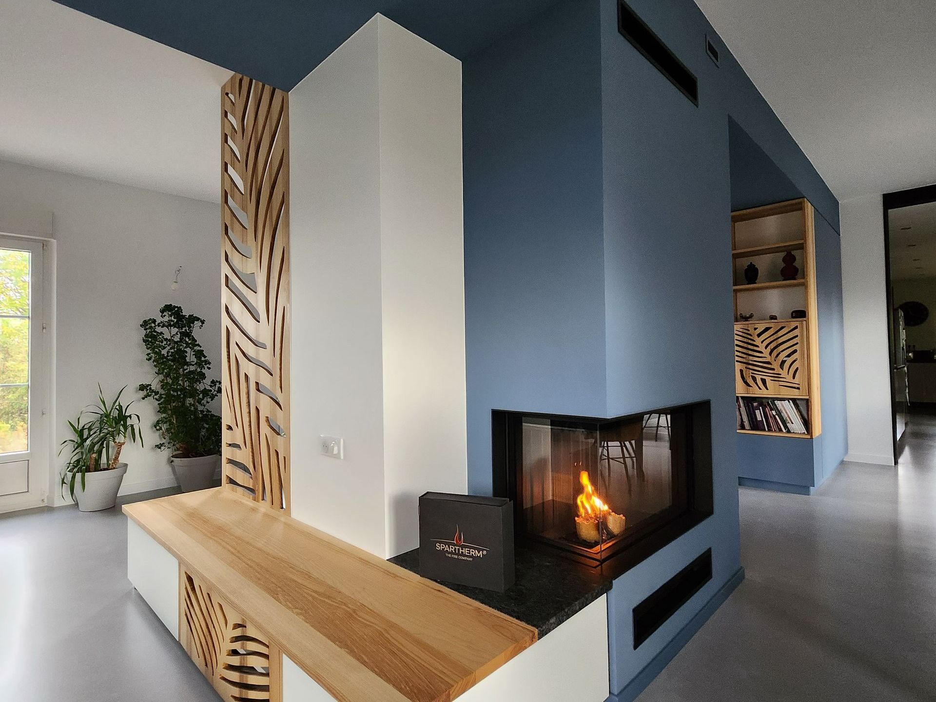 Cheminée avec insert bleu, blanc et bois.