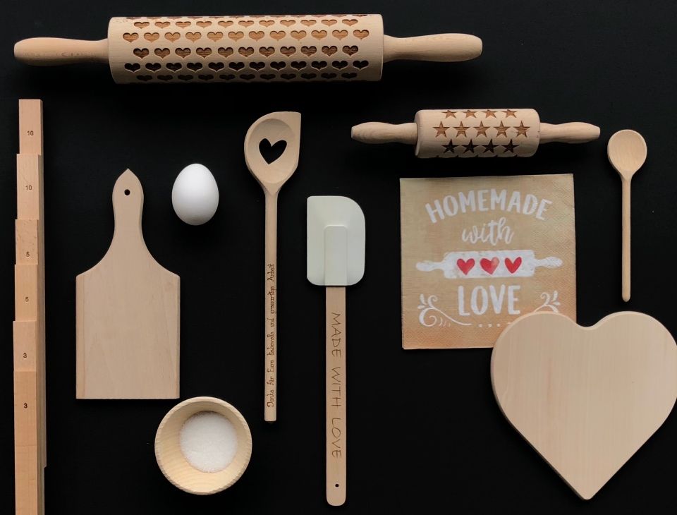 Holzwarenfabrik Müller AG - Verschiedene Küchenutensilien aus Holz vor schwarzem Hintergrund