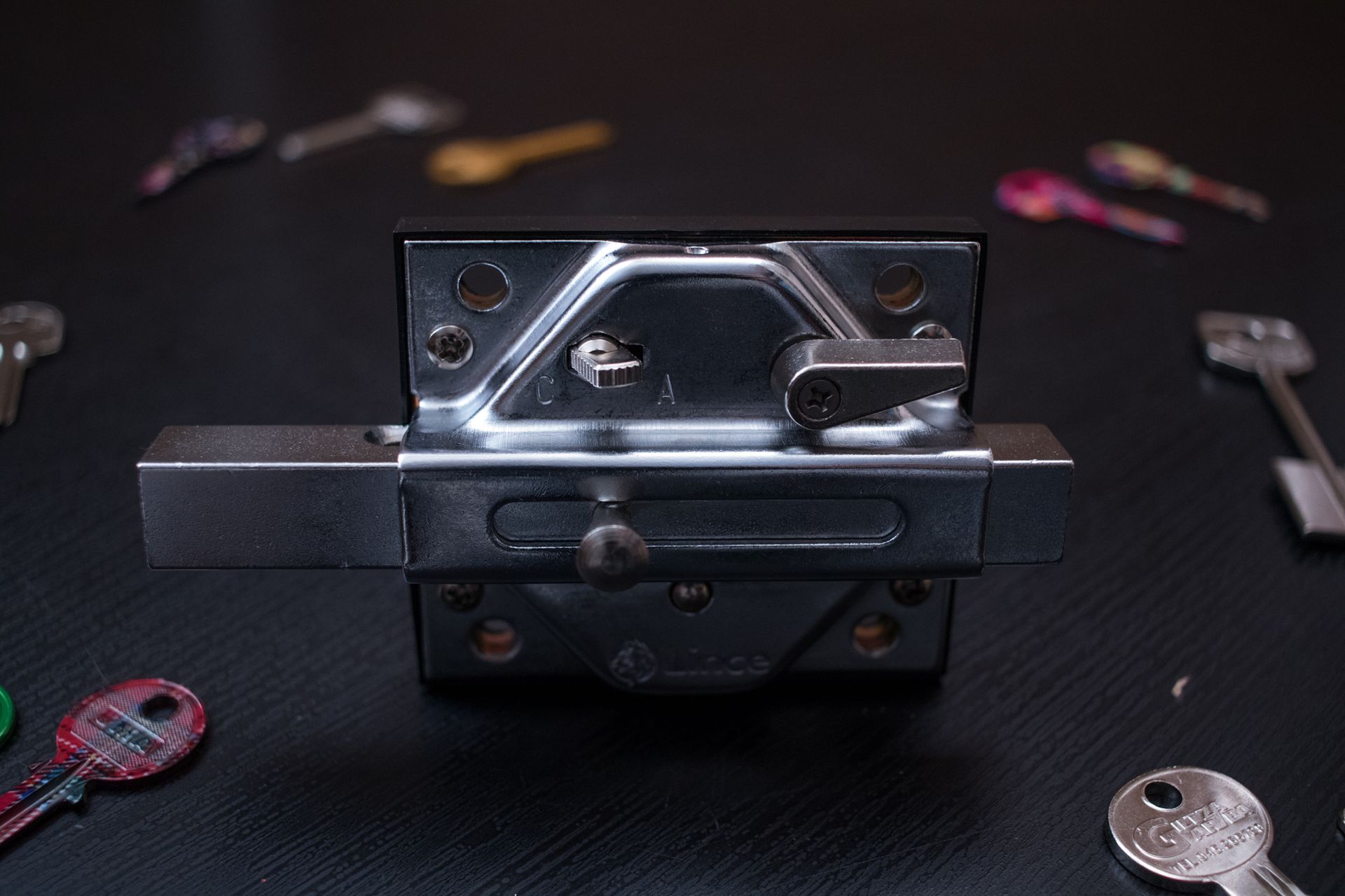 Un primer plano de una cerradura con llaves alrededor de ella sobre una mesa.