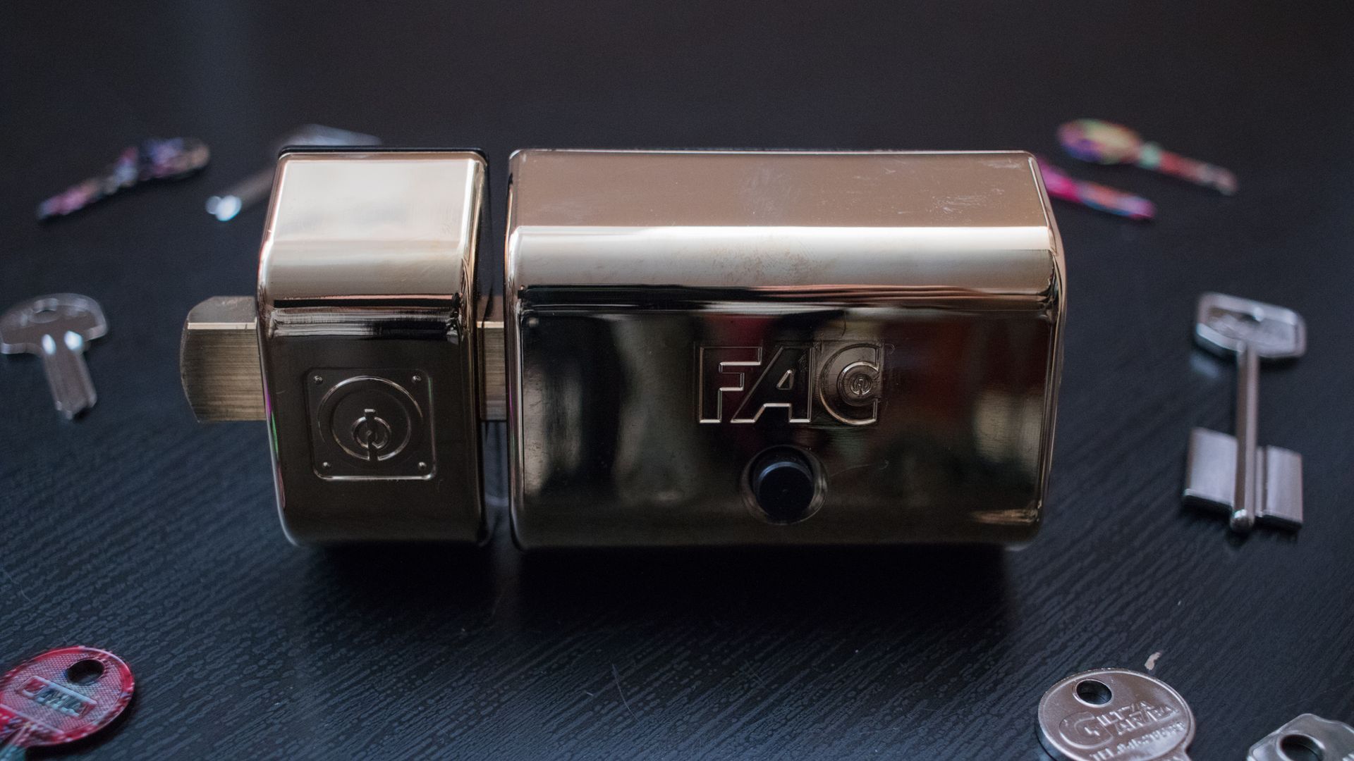 Un primer plano de una cerradura y llaves sobre una mesa.