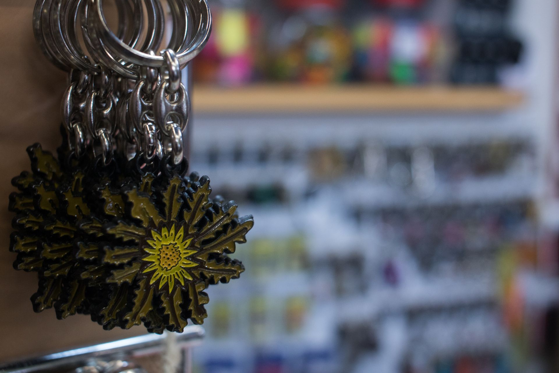 Una persona sostiene un montón de llaveros con una flor amarilla en ellos.