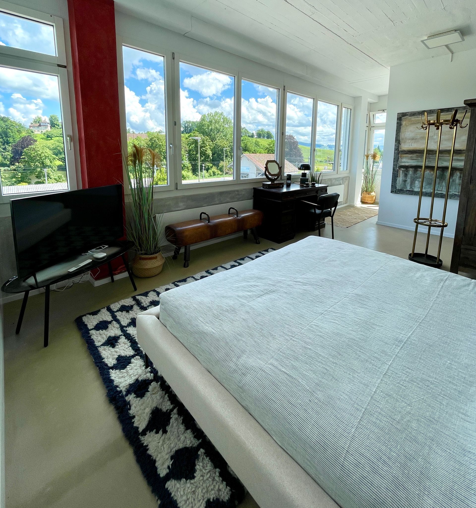 Ein Schlafzimmer mit großem Bett und vielen Fenstern