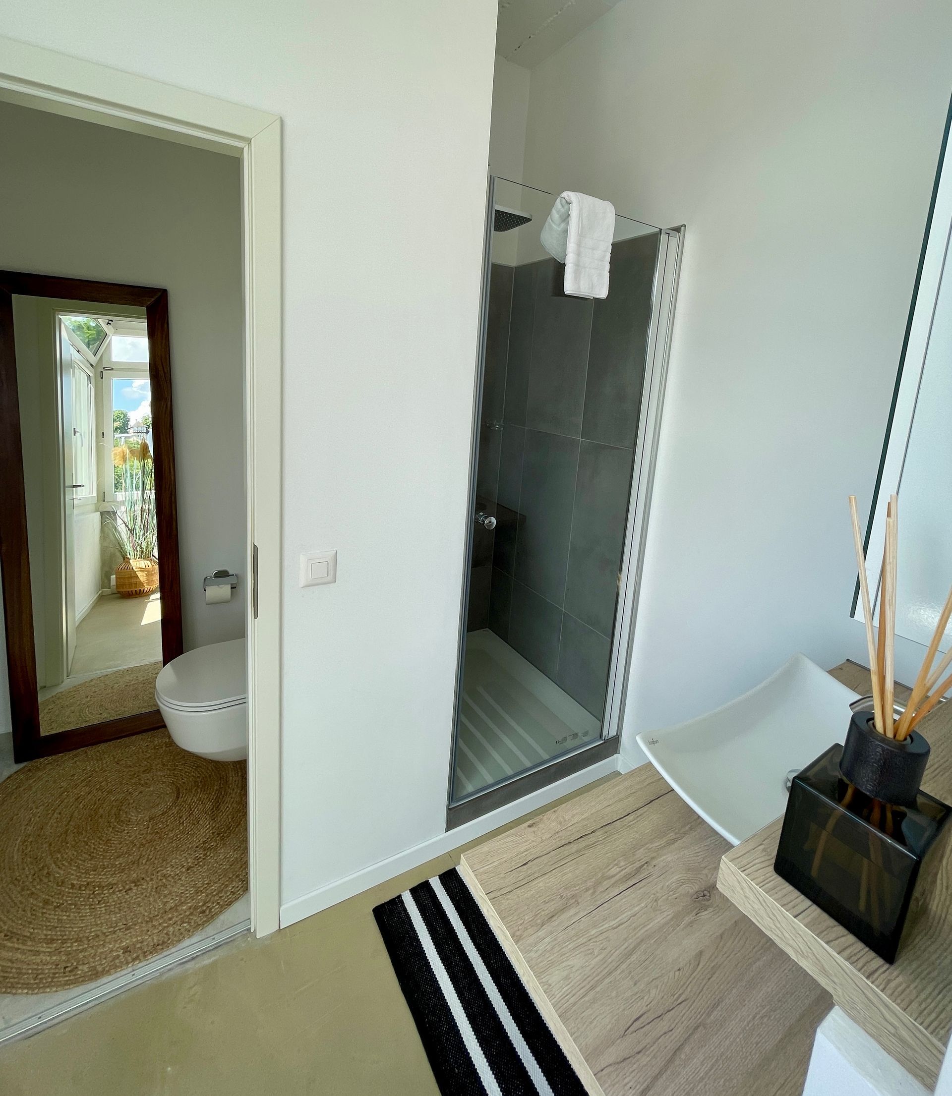 Ein Badezimmer mit Toilette, Waschbecken, Spiegel und Dusche.