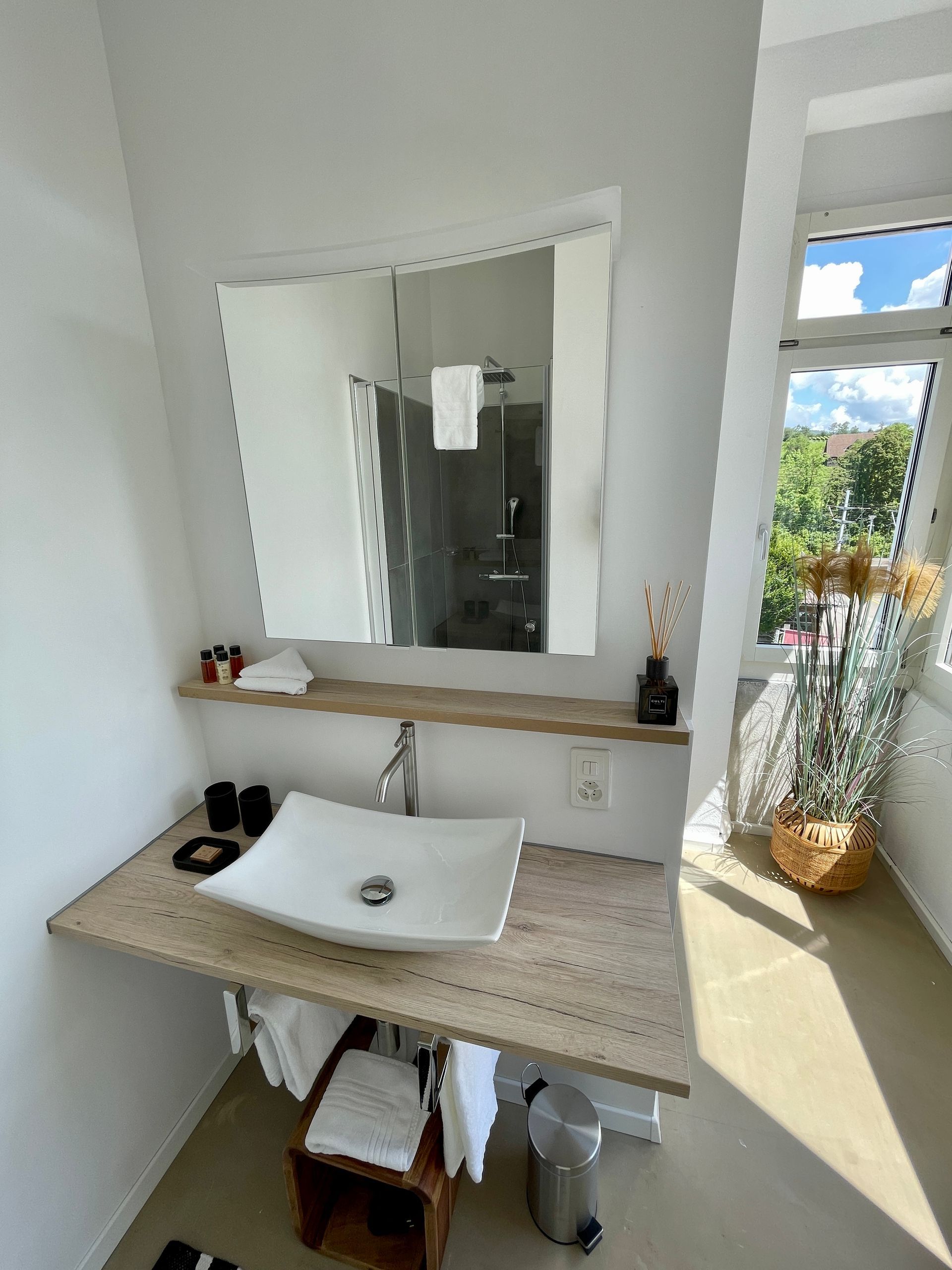 Ein Badezimmer mit Waschbecken, Spiegel und Fenster