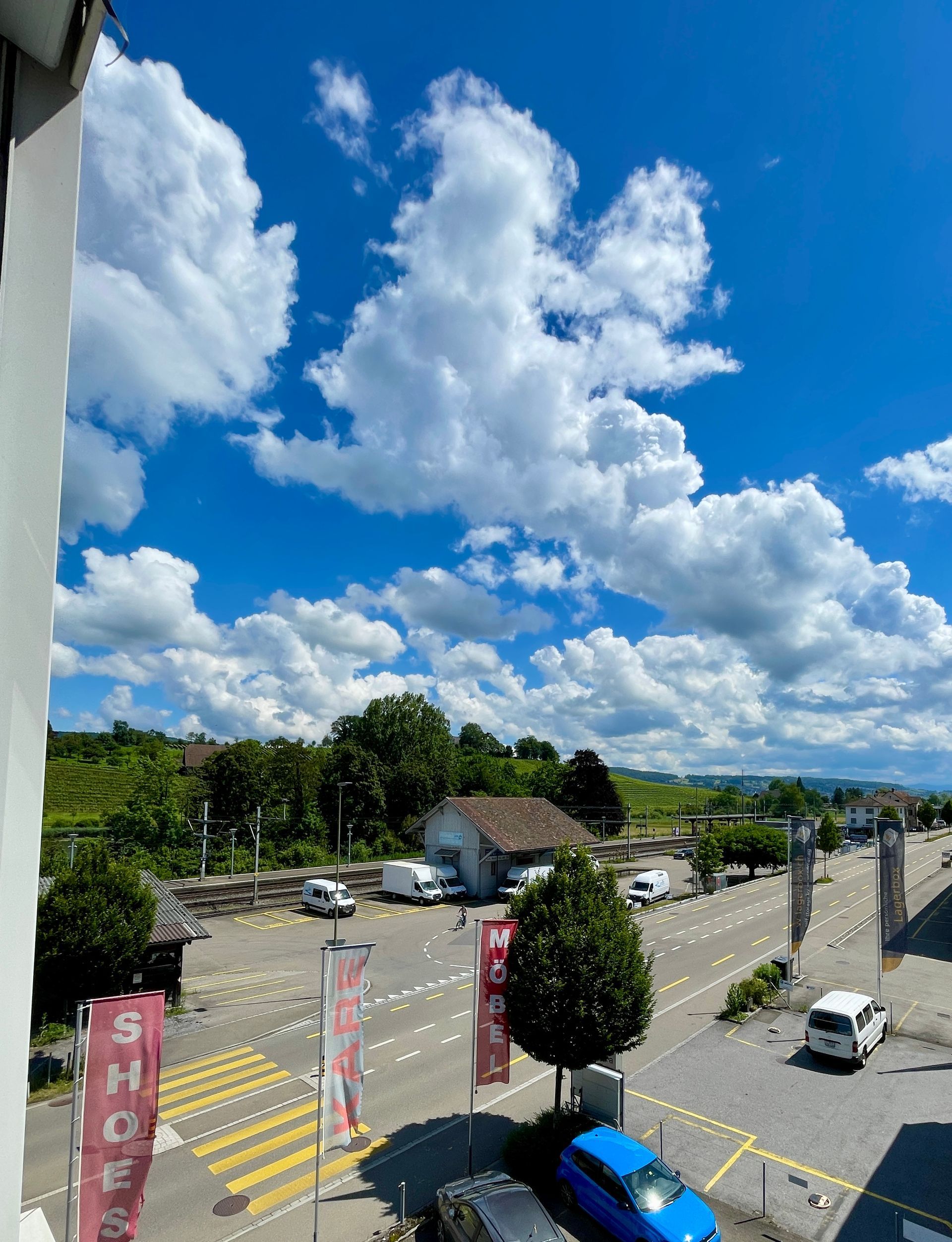 Ein blaues Auto parkt am Straßenrand vor einem Gebäude.