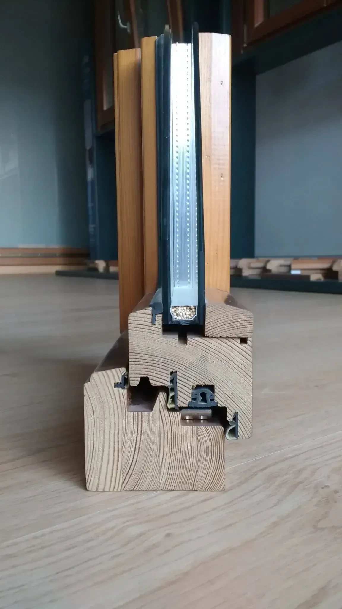 Primer plano de un dispositivo mecánico de madera y metal que se encuentra sobre el suelo de un taller.