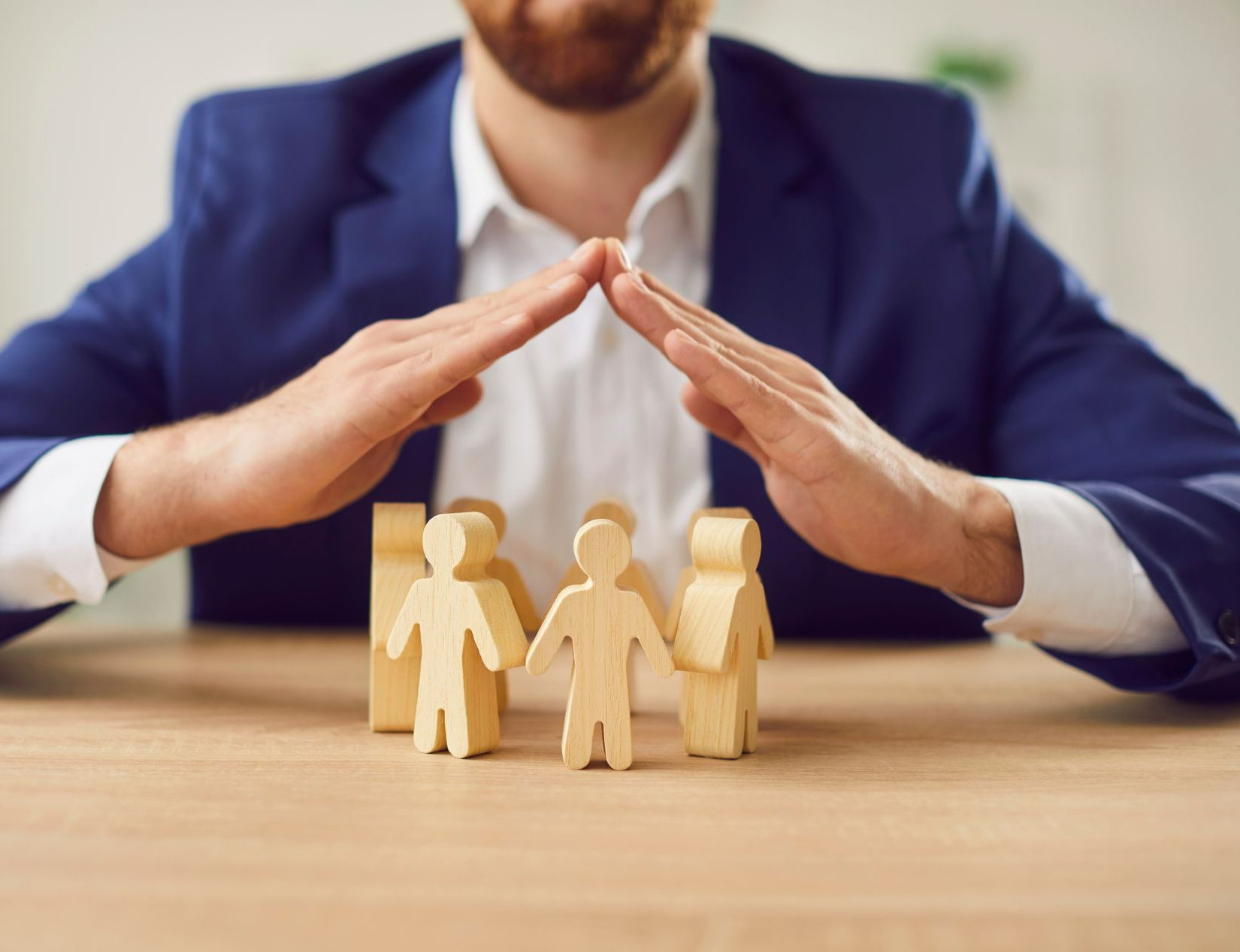 Mains qui protègent des figurines en bois