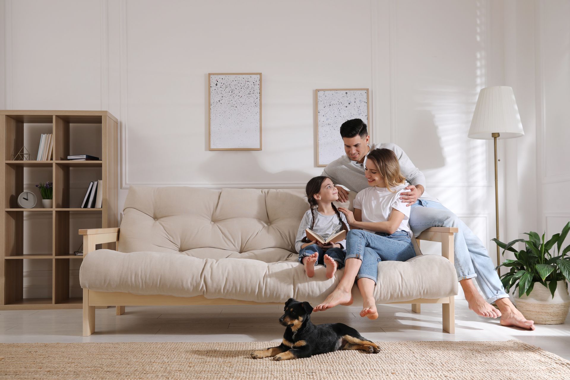 Enfant dans un canapé avec ses parents et un livre