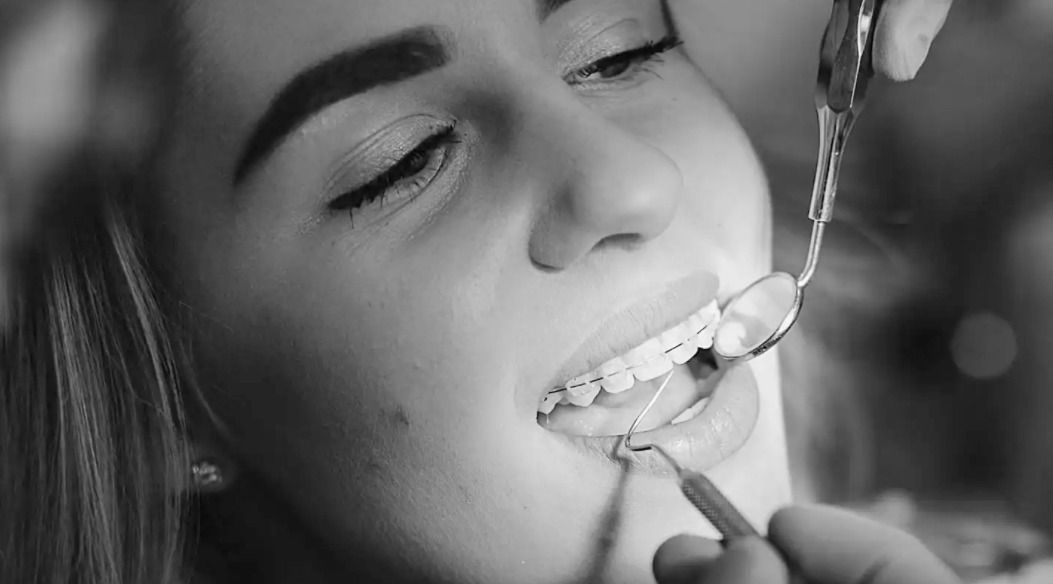 Mujer con aparatos dentales durante un examen dental en el consultorio de un dentista.
