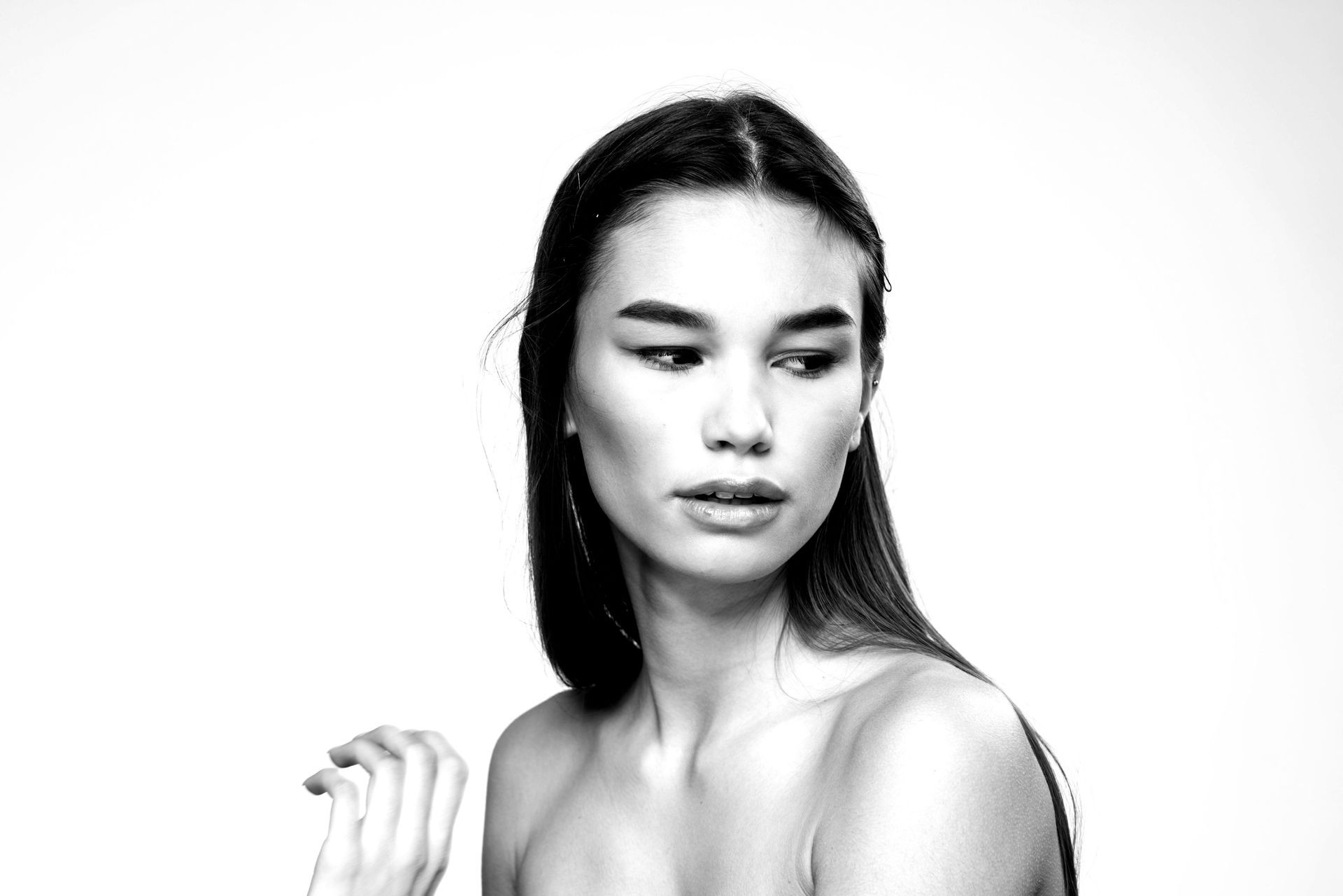 Mujer con cabello largo y oscuro mirando hacia un lado, retrato en blanco y negro.