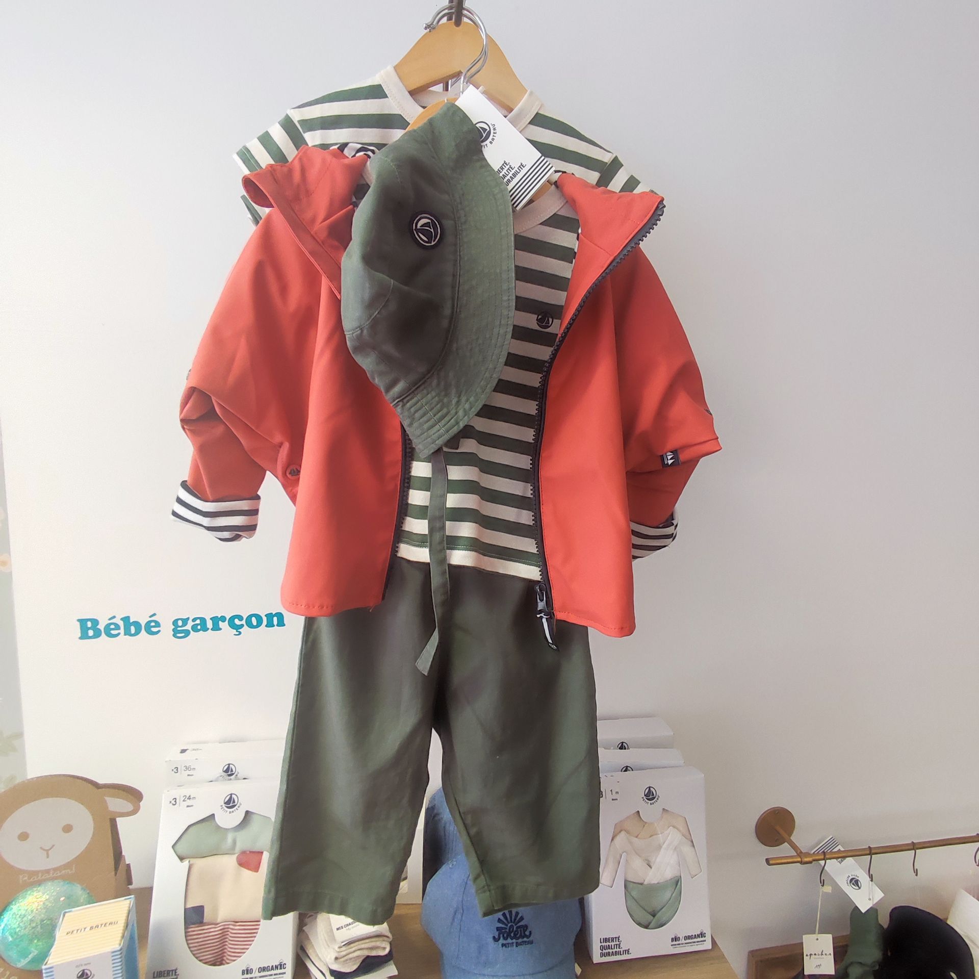 Tenue pour enfants avec un ciré orange, une marinière et un pantalon