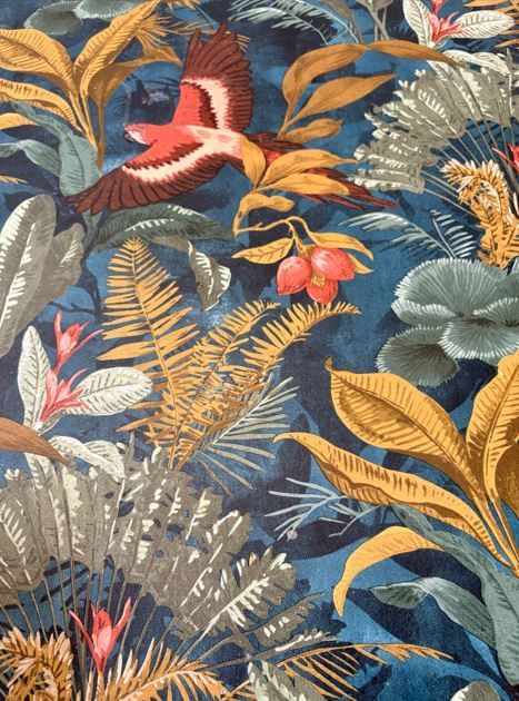 Tela tropical: pájaro en vuelo sobre un exuberante follaje azul, dorado y verde.