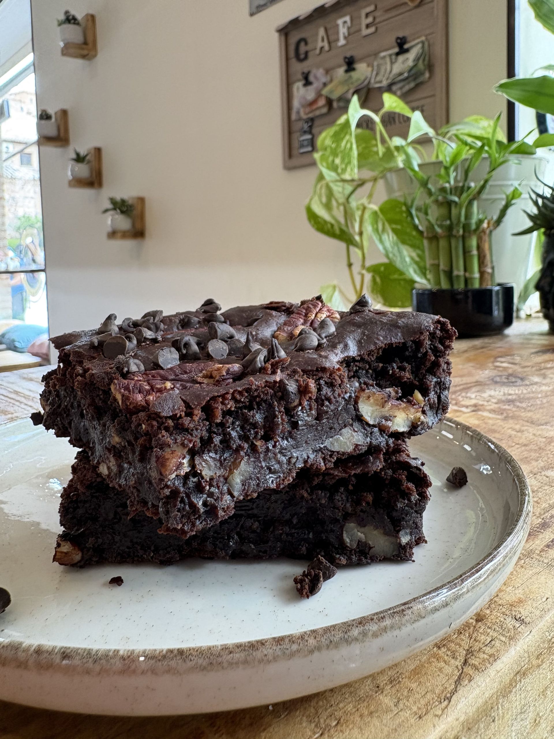 Dos brownies de chocolate apilados en un plato, con chispas de chocolate y nueces, en el interior.
