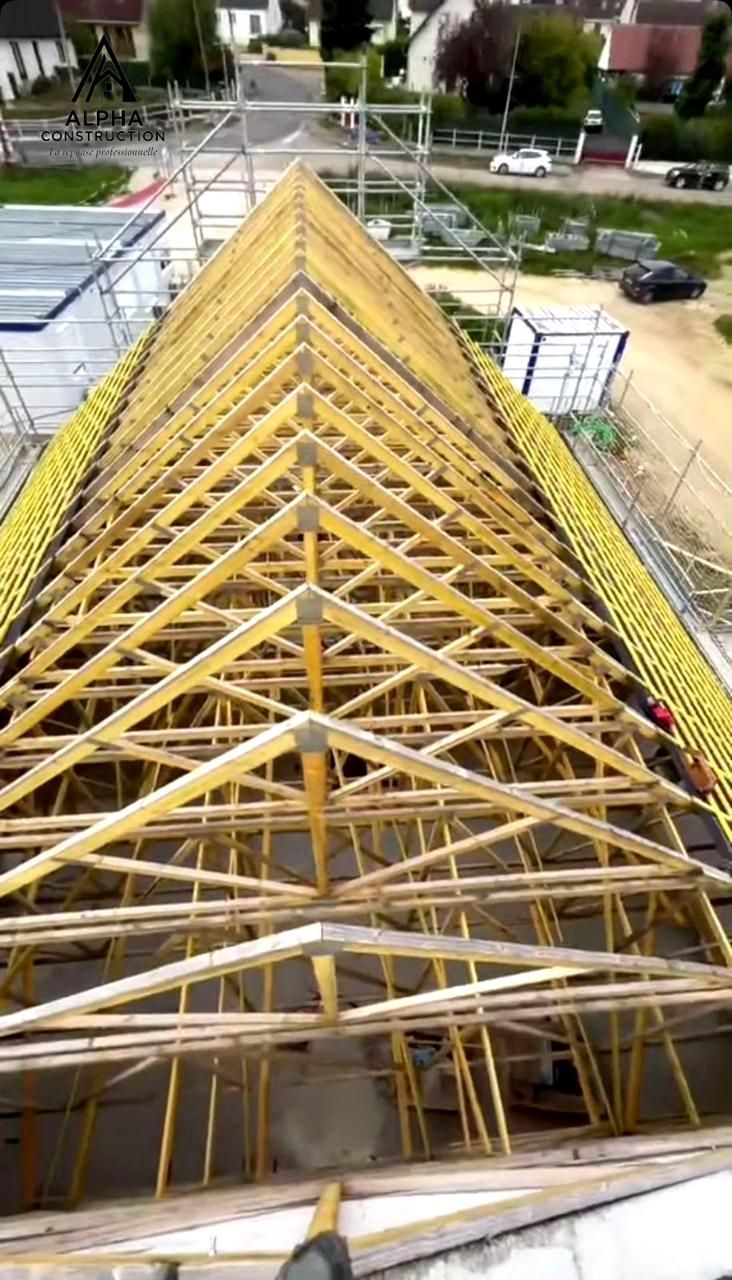 Vue de dessus d'une charpente en bois en construction dans un quartier résidentiel.