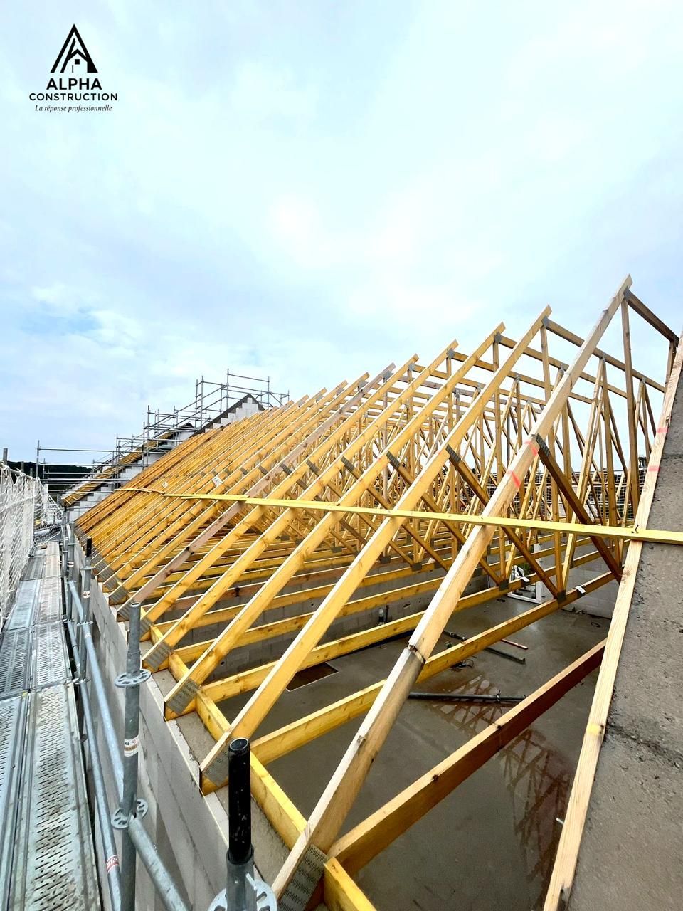 Fermes de toit en bois en construction, échafaudage, ciel bleu.
