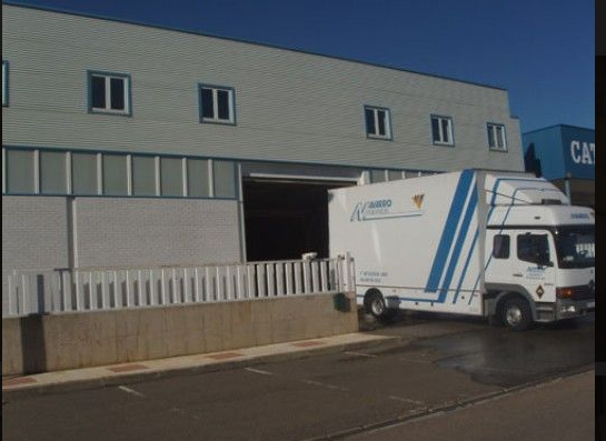 Un camión blanco y azul está estacionado frente a un edificio.