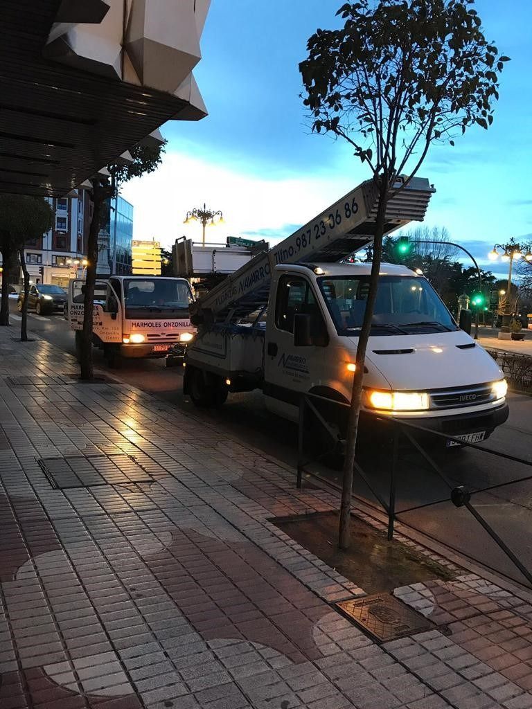 Dos furgonetas blancas están estacionadas al costado de la carretera.
