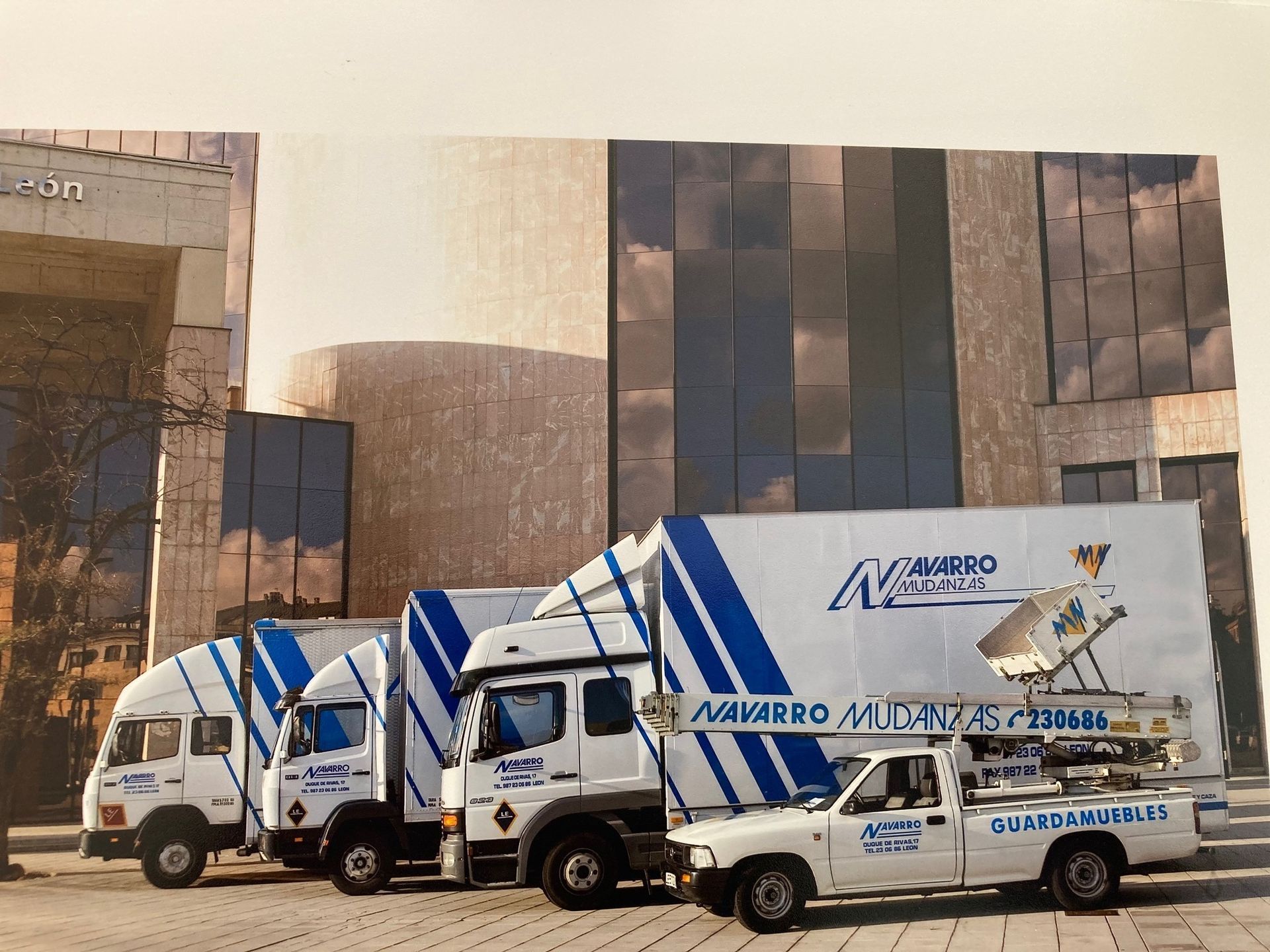 Tres camiones de mudanzas están estacionados frente a un edificio