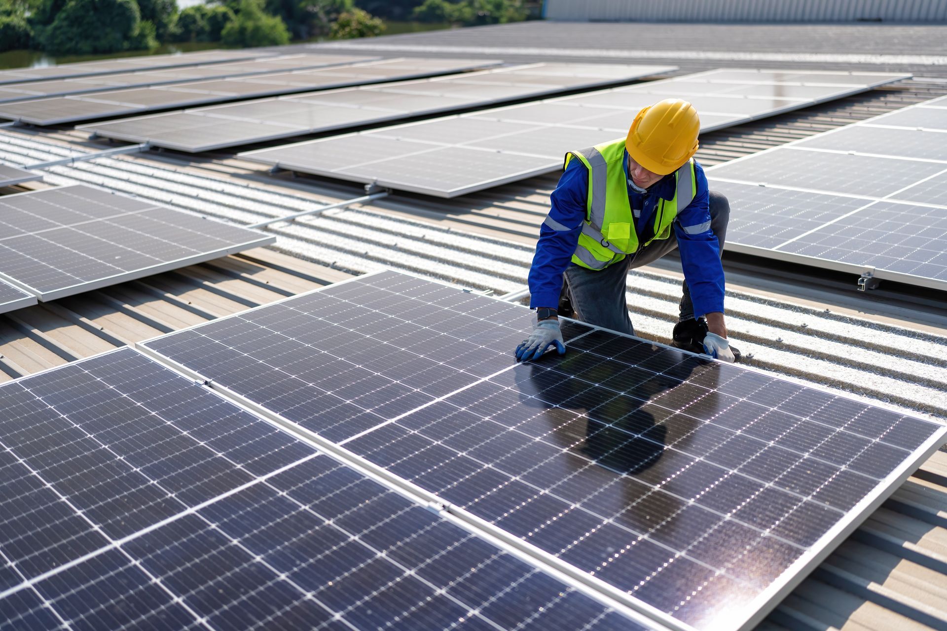 Ein Mann installiert Solarmodule auf dem Dach eines Gebäudes.