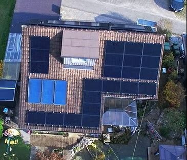 Eine Luftaufnahme eines Hauses mit Solarmodulen auf dem Dach