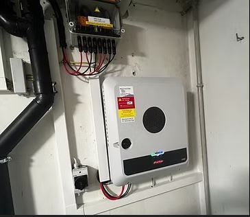 Ein Solarkasten wird an einer Wand in einem Raum montiert. Foto von Dönni Solar & Bau
