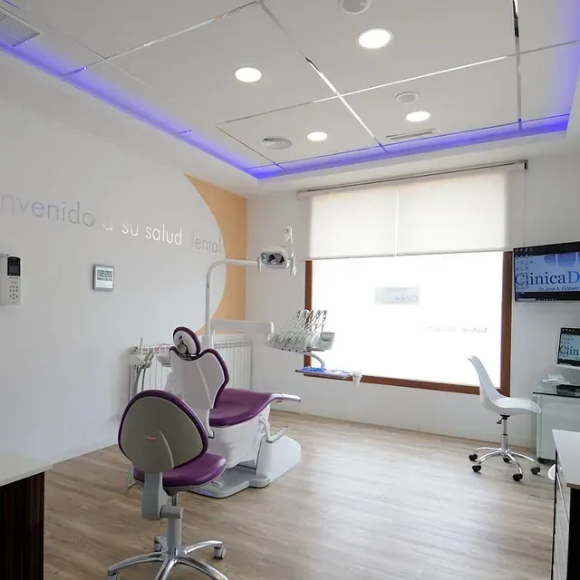 Un consultorio dental con una silla morada y una ventana.