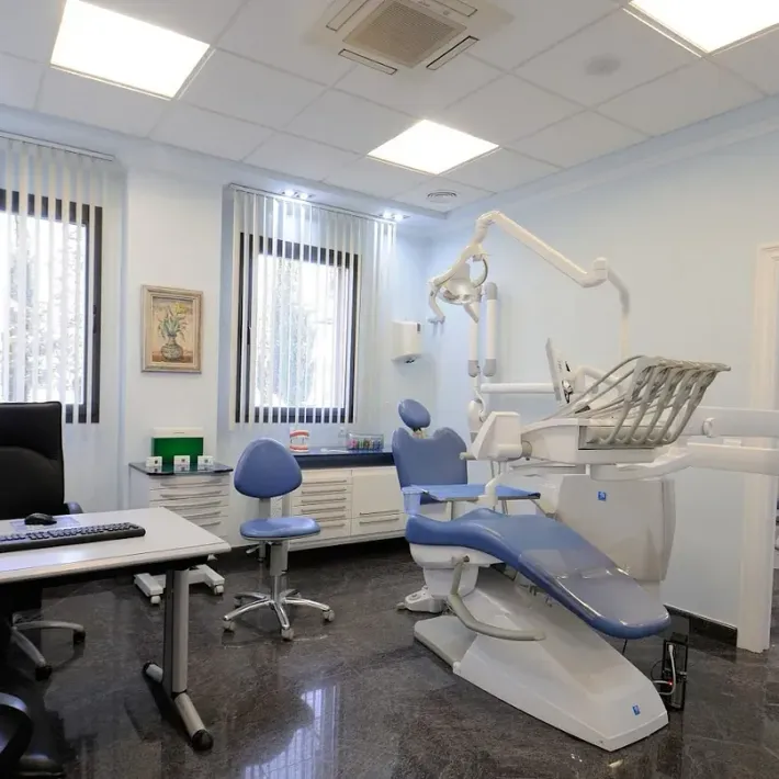 Un consultorio dental con un sillón dental y un escritorio.