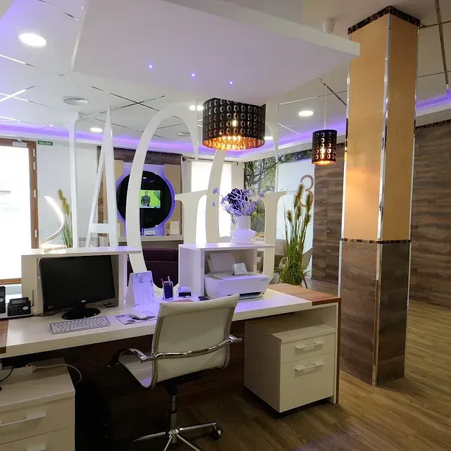 Un escritorio con una computadora y una silla en una habitación.