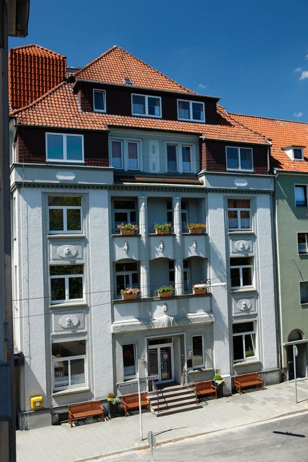 Ein großes weißes Gebäude mit einem roten Ziegeldach