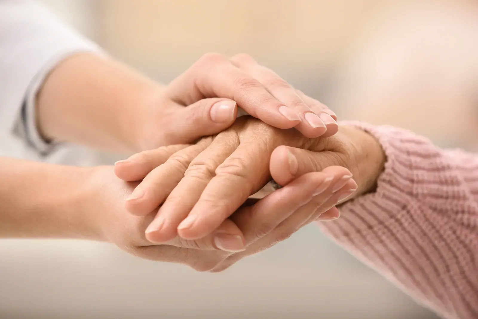 Eine Nahaufnahme einer Person, die die Hand einer anderen Person hält.