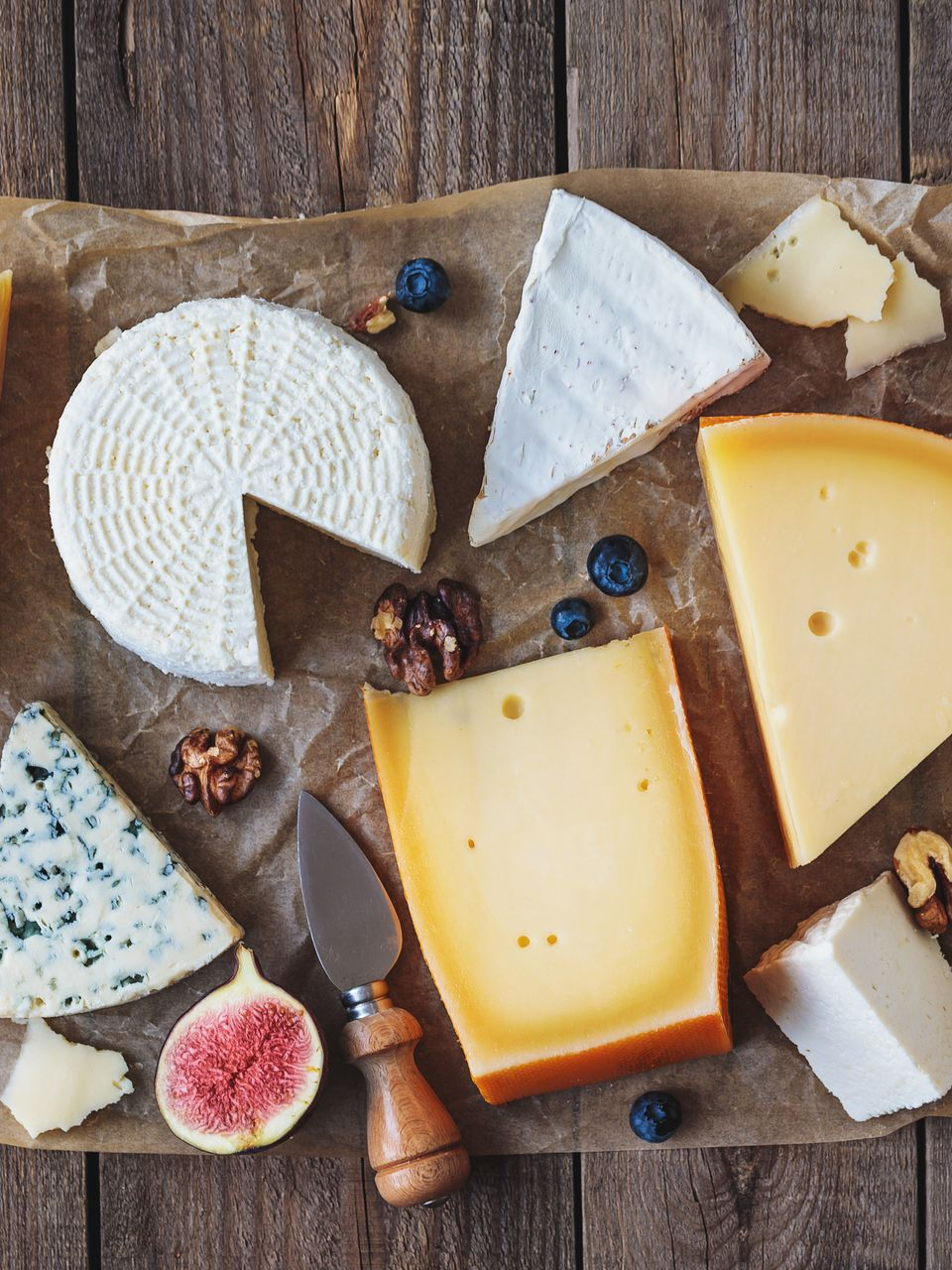 Plateau de fromages décoré avec des figues, des noix et des myrtilles.