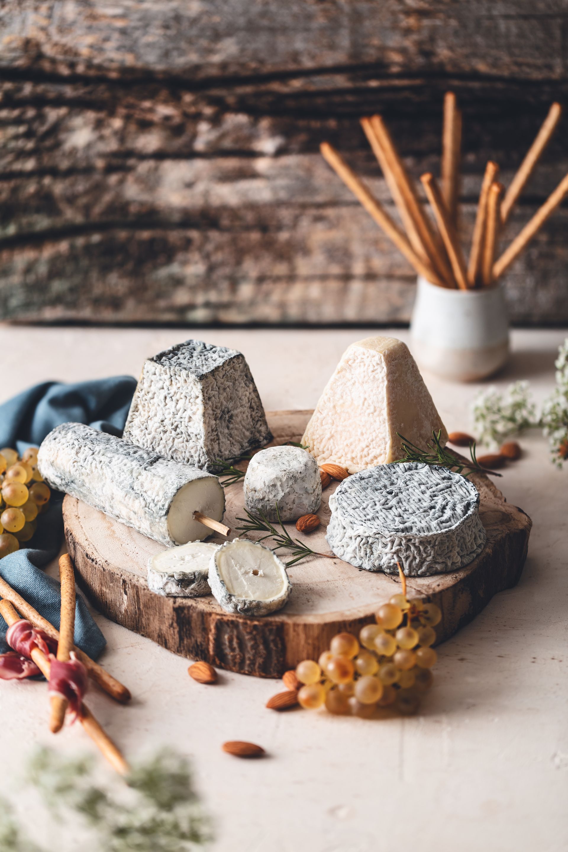 Fromages disposés sur un plateau en rondin de bois.