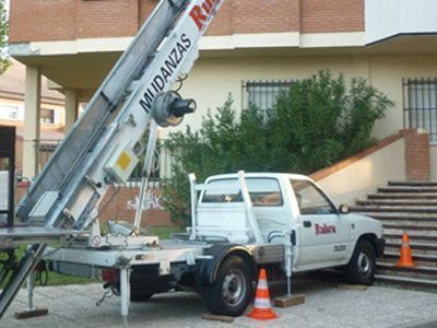 Un camión blanco con la palabra mudanzas en el costado.