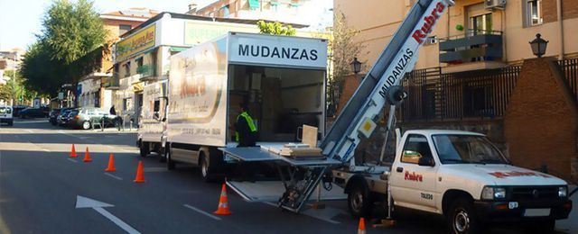 Un camión blanco está estacionado al costado de la carretera al lado de un camión en movimiento.