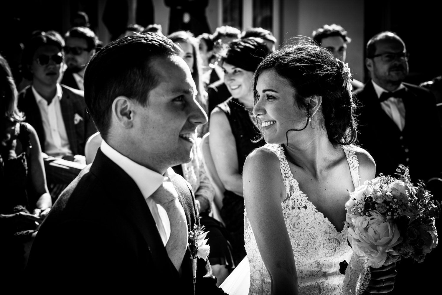 Novios sonriéndose durante una ceremonia nupcial. Blanco y negro.