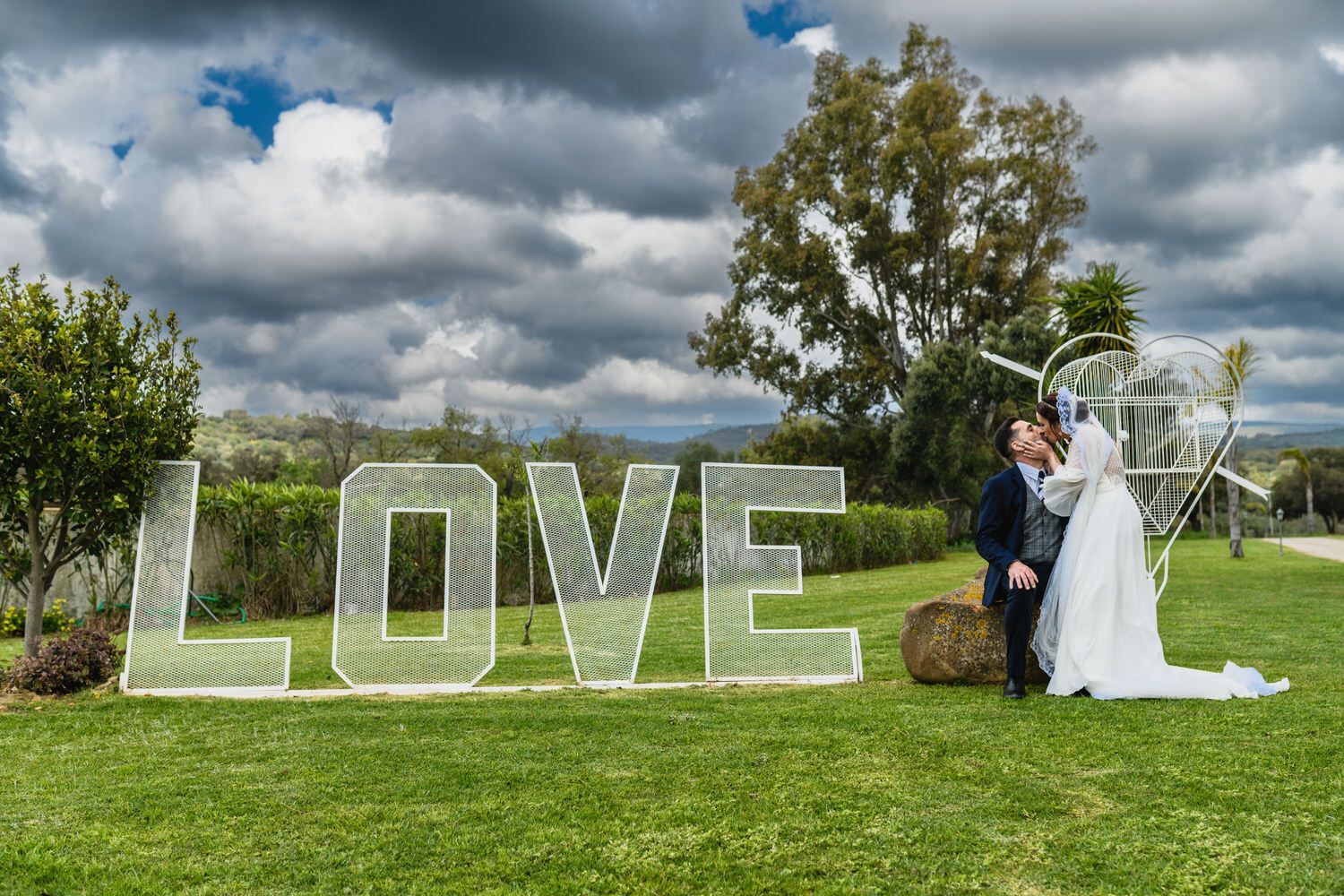 Pareja besándose junto a un cartel de 