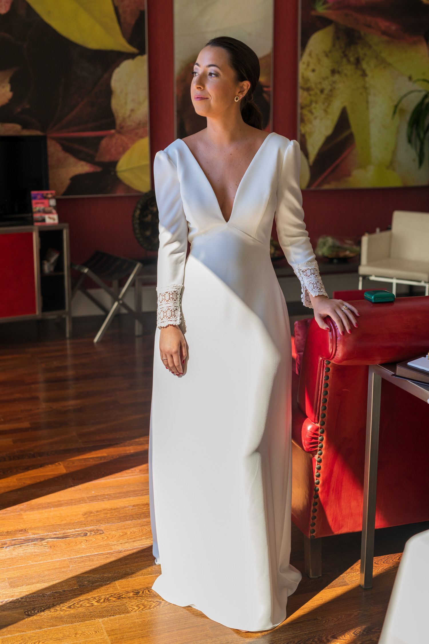 Mujer con vestido de novia blanco, escote en V profundo, mangas largas