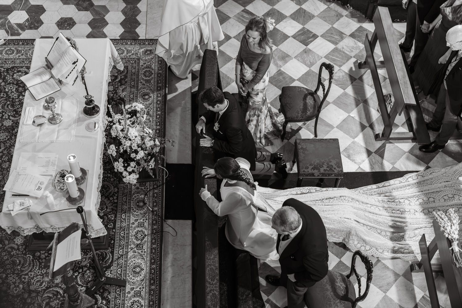 Ceremonia de boda desde arriba; pareja en el altar, invitados observan, interior de la iglesia, blanco y negro.