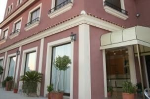 Un edificio rosa con un toldo blanco sobre la entrada.