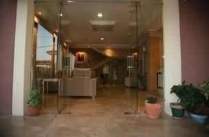 Una habitación con muchas plantas en macetas y una puerta de vidrio.